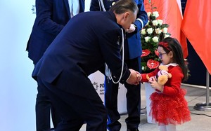 Na zdjęciu widać policjanta oraz dziewczynkę