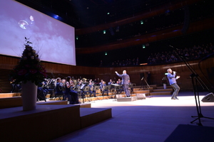 Zdjęcie. Orkiestra, dyrygent oraz wokalista na scenie