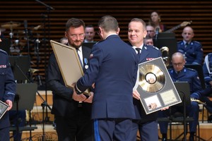 Zdjęcie przedstawia policjantów odbierających złote płyty