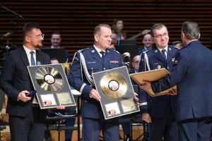 Zdjęcie przedstawia policjantów otrzymujących złote płyty