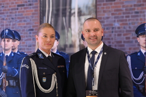 Zdjęcie przedstawia policjantkę oraz mężczyznę z plakietką organizator