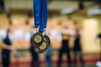 Medale za udział w konkursie strzeleckim, w tle strzelnica