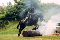Policjant na koniu przeskakującym przez palącą się słomę