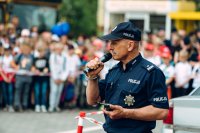Policjant z mikrofonem tłumaczy elementy pokazu interwencji