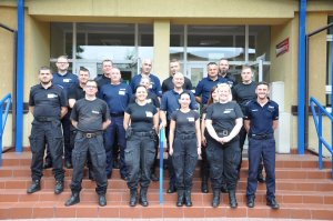 Grupa policjantów stojących przed budynkiem Szkoły Policji w Katowicach