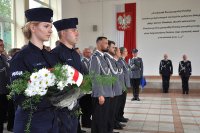 Poczet kwiatowy, w tle policjanci i komendanci