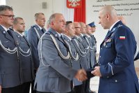 Komendant Główny Policji z komendantem szkoły odznacza policjantów