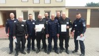 Grupa umundurowanych policjantów stojąca przed budynkiem Szkoły Policji w Katowicach