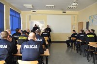 Umundurowani policjanci siedzący w sali wykładowej