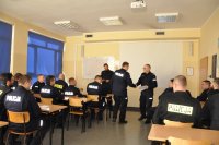 Umundurowani policjanci siedzący w sali wykładowej