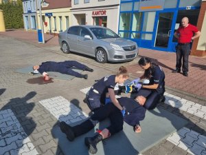 Policjanci podczas zajęć biorą udział w symulacji udzielania pierwszej pomocy na terenie  Wielofunkcyjnego Centrum Symulacji Szkoły Policji w Katowicach.
Zajęcia odbywały się na sali pierwszej pomocy i na terenie  Wielofunkcyjnego Centrum Symulacji